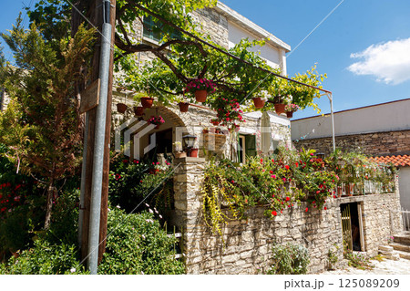 Charming stone house adorned with vibrant flowers in Levkara, Cyprus on a sunny day Charming stone house adorned with vibrant flowers in Levkara, Cyprus on a sunny day 125089209