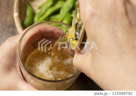 缶ビールを手酌でグラスに注ぐ 125089792