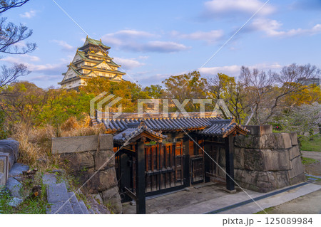 夕日に照らされる大阪城天守閣と北仕切門　桜咲く季節 125089984