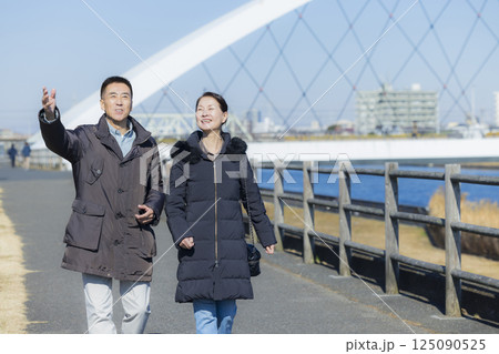 散歩をするコートを着たミドル夫婦 125090525