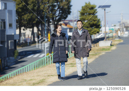 散歩をするコートを着たミドル夫婦 125090526