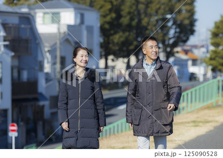 散歩をするコートを着たミドル夫婦 125090528