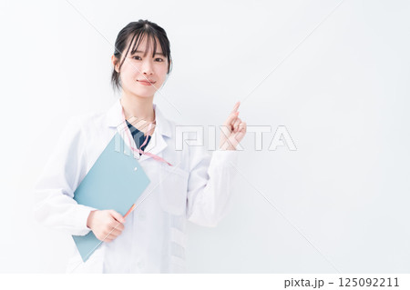 クリニックを紹介する指差しポーズの女性医師 白バック クリニックを紹介する指差しポーズの女性医師 白バック 125092211