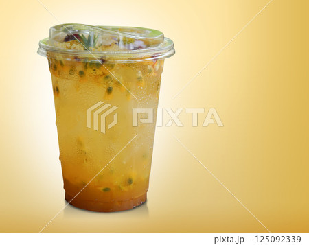 fresh yellow passion fruit in a clear plastic glass. Decorated with flowers and leaves on gradient yellow background, fruit, nature, drink, fresh, copy space 125092339