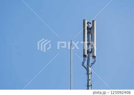 青空に映える携帯電話の基地局アンテナと避雷針 125092406