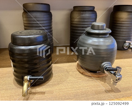 棚に並んだコック付きの焼酎の甕 125092499