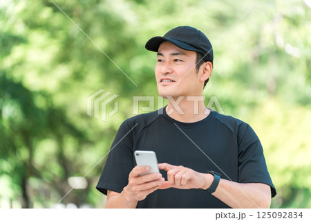 運動中にスマホで健康管理,ヘルスチェックする中年アジア人男性 125092834