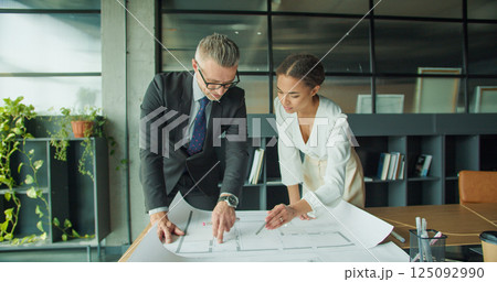 Architects reviewing blueprint in modern office space 125092990