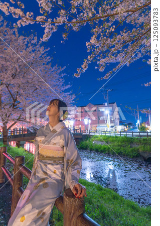 花筏が浮かぶ川越新河岸川の桜ライトアップとミドルの着物の女性 花筏が浮かぶ川越新河岸川の桜ライトアップとミドルの着物の女性 125093783