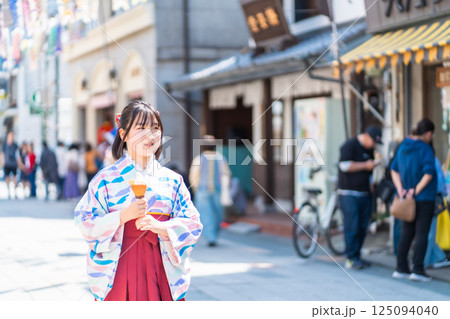 川越大正浪漫通りでソフトクリームを食べながら袴で街歩きする女の子 川越大正浪漫通りでソフトクリームを食べながら袴で街歩きする女の子 125094040