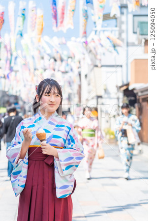 川越大正浪漫通りでソフトクリームを食べながら袴で街歩きする女の子 川越大正浪漫通りでソフトクリームを食べながら袴で街歩きする女の子 125094050