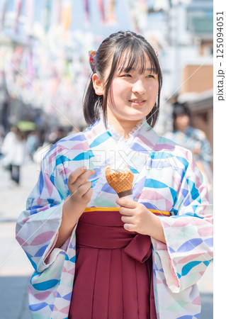 川越大正浪漫通りでソフトクリームを食べながら袴で街歩きする女の子 125094051