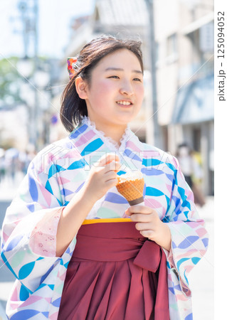川越大正浪漫通りでソフトクリームを食べながら袴で街歩きする女の子 125094052