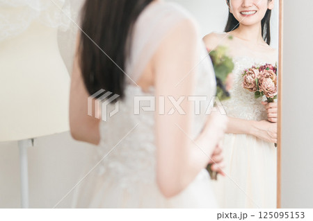 ウェディングドレスの試着,結婚式のブーケ,花束選びの打ち合わせをする女性 125095153