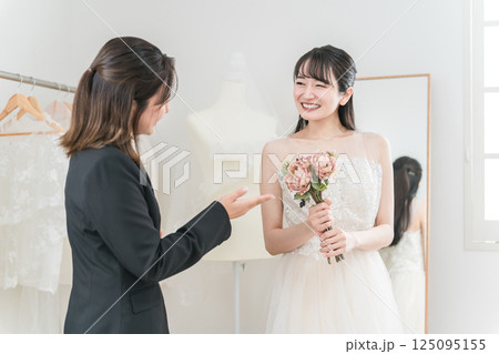 ウェディングプランナーと結婚式のブーケ,花束選びの打ち合わせをする女性 125095155