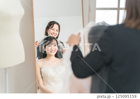 ブライダル,ウェディング,結婚式の準備をする花嫁とウェディングプランナーの女性(ベール) ブライダル,ウェディング,結婚式の準備をする花嫁とウェディングプランナーの女性(ベール) 125095159
