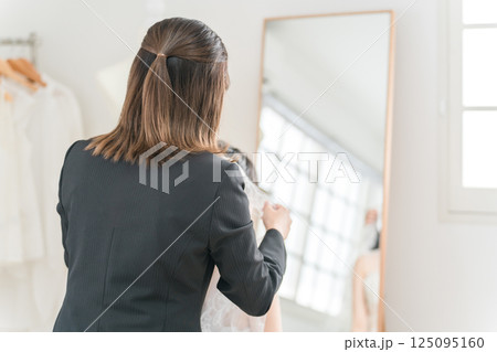 ブライダル,ウェディング,結婚式の準備をする花嫁とウェディングプランナーの女性(ベール) 125095160