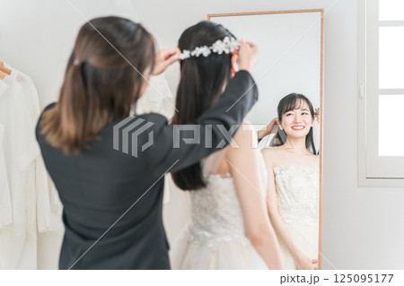 結婚式,ウェディングの髪型,ヘアスタイルの打ち合わせをする花嫁とウェディングプランナーの女性 結婚式,ウェディングの髪型,ヘアスタイルの打ち合わせをする花嫁とウェディングプランナーの女性 125095177