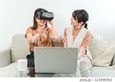 VRゴーグルをつけてゲーム,バーチャル体験,操作するアジア人女性(AR,MR) 125096302
