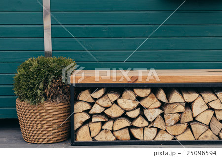 Heating the house. Firewood for fireplace and stove. Big stumps. Rural street. A pile of wooden logs. Woodshed outside. Rural landscape. Sawn trees. Heating the house. Firewood for fireplace and stove. Big stumps. Rural street. A pile of wooden logs. Woodshed outside. Rural landscape. Sawn trees. 125096594