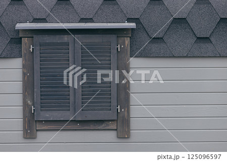 Gray wood plank facade with window closed with wooden shutters Gray wood plank facade with window closed with wooden shutters 125096597