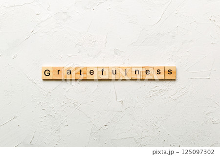 gratefulness word written on wood block. gratefulness text on cement table for your desing, concept 125097302