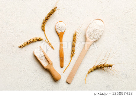Flat lay of Wheat flour in wooden bowl with wheat spikelets on colored background. world wheat crisis 125097418