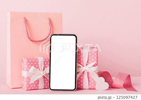 mobile phone with blank screen on colored background with hearts, calendar and gift box, valentine day concept perspertive view flat lay mobile phone with blank screen on colored background with hearts, calendar and gift box, valentine day concept perspertive view flat lay 125097427
