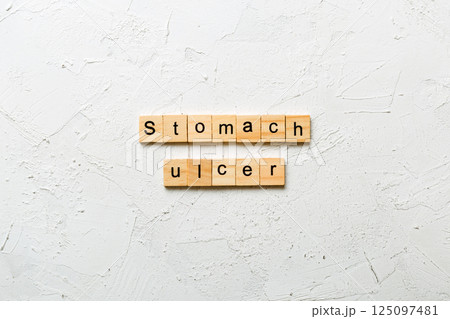 stomach ulcer word written on wood block. stomach ulcer text on table, concept 125097481