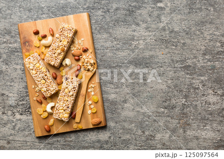 Various granola bars on table background. Cereal granola bars. Superfood breakfast bars with oats, nuts and berries, close up. Superfood concept Various granola bars on table background. Cereal granola bars. Superfood breakfast bars with oats, nuts and berries, close up. Superfood concept 125097564