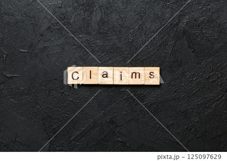 claims word written on wood block. claims text on cement table for your desing, concept 125097629
