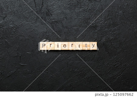 priority word written on wood block. priority text on table, concept priority word written on wood block. priority text on table, concept 125097662