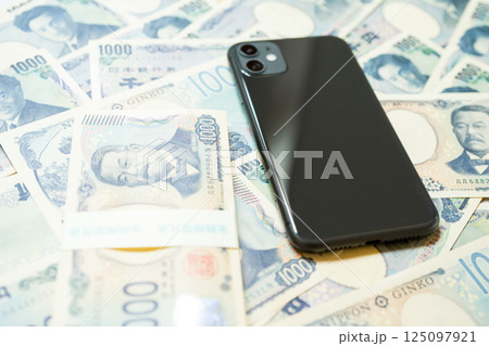 たくさんの千円札とスマホ たくさんの千円札とスマホ 125097921