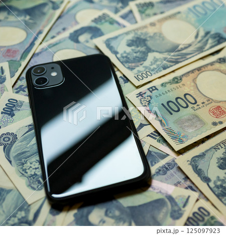 たくさんの千円札とスマホ たくさんの千円札とスマホ 125097923