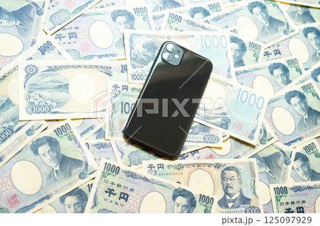 たくさんの千円札とスマホ 125097929