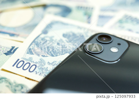 たくさんの千円札とスマホ たくさんの千円札とスマホ 125097933