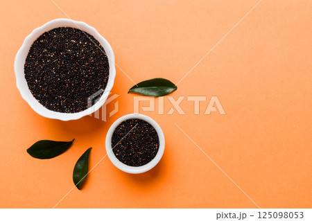 quinoa seeds in bowl on colored background. Healthy kinwa in small bowl. Healthy superfood quinoa seeds in bowl on colored background. Healthy kinwa in small bowl. Healthy superfood 125098053