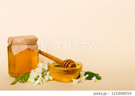 robinia honey bollte with acacia blossoms on colored table 125098054