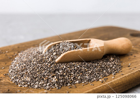 Chia seeds in bowl and spoon on colored background. Healthy Salvia hispanica in small bowl. Healthy superfood Chia seeds in bowl and spoon on colored background. Healthy Salvia hispanica in small bowl. Healthy superfood 125098066