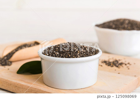 Chia seeds in bowl and spoon on colored background. Healthy Salvia hispanica in small bowl. Healthy superfood 125098069