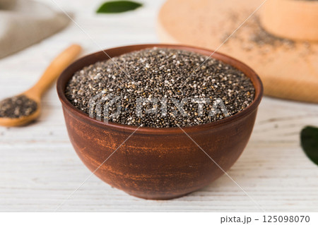 Chia seeds in bowl and spoon on colored background. Healthy Salvia hispanica in small bowl. Healthy superfood 125098070