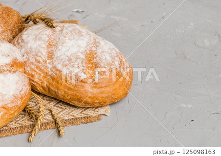 Homemade natural breads. Different kinds of fresh bread as background, perspective view with copy space Homemade natural breads. Different kinds of fresh bread as background, perspective view with copy space 125098163