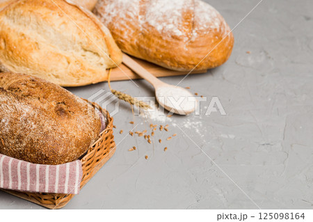Homemade natural breads. Different kinds of fresh bread as background, perspective view with copy space Homemade natural breads. Different kinds of fresh bread as background, perspective view with copy space 125098164