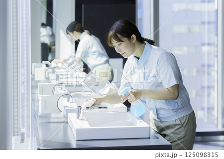 オフィスビルの洗面所の洗面台を拭く若い女性清掃員　撮影協力：学校法人電波学園 東京電子専門学校 125098315
