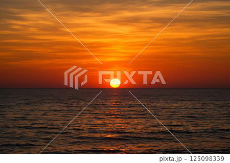 水平線に沈む夕陽 125098339