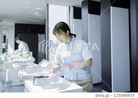 オフィスビルの洗面所の洗面台を拭く若い女性清掃員　撮影協力：学校法人電波学園 東京電子専門学校 125098935