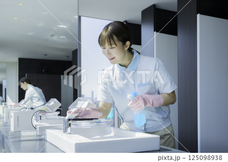 オフィスビルの洗面所の洗面台を拭く若い女性清掃員　撮影協力：学校法人電波学園 東京電子専門学校 125098938