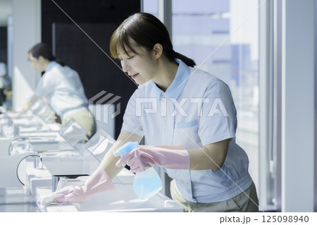 オフィスビルの洗面所の洗面台を拭く若い女性清掃員　撮影協力：学校法人電波学園 東京電子専門学校 125098940