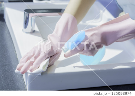 オフィスビルの洗面所の洗面台を拭く若い女性清掃員の手元　撮影協力：学校法人電波学園 東京電子専門学校 125098974
