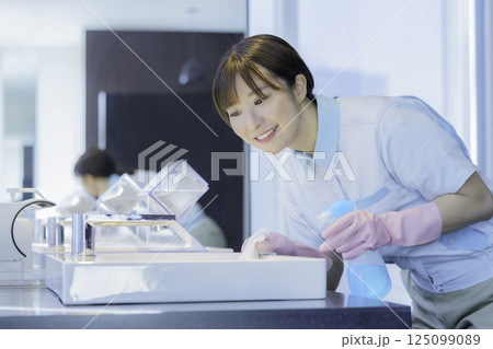 オフィスビルの洗面所の洗面台を拭く若い女性清掃員　撮影協力：学校法人電波学園 東京電子専門学校 125099089